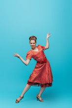 Attractive, Stylish Dancer Looking At Camera While Dancing Boogie-woogie On Blue Background