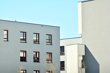 Contemporary residential building exterior in the daylight. Modern apartment buildings on a sunny day with a blue sky. Facade of a modern apartment building