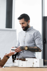 Wall Mural - virtual reality architect holding virtual reality headset talking with colleague