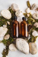 Wall Mural - Flat lay composition with brown glass bottles over Natural background of real tree bark, moss on light stone surface with copy space for mockup of body care organic cosmetics.