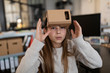 © Westend61 - Girl with cardboard VR glasses in office