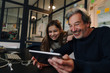 © Westend61 - Happy casual senior businessman and girl using tablet in office