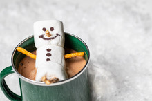 Above View Of Snowman Laying In A Mug Of Hot Chocolate Or Coffee 