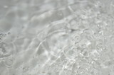 Fototapeta Dmuchawce - The surface of the water in a white container