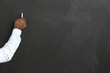 © Pixel-Shot - Hand of African-American teacher writing on blackboard in classroom
