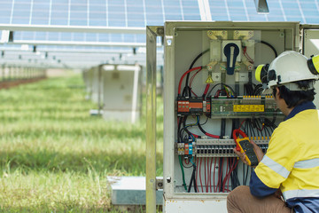 Workers use Clamp meter to measure the current of electrical wires produced from solar energy for confirm to systems working normal