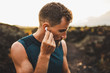 © Oleg Breslavtsev - Man using wireless earphones air pods on running outdoors. Active lifestyle concept.