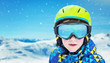 Boy with modern ski green helmet, yellow glasses and blue jacket. Reflection of snowy peaks on glasses. Close-up, copy space beside
