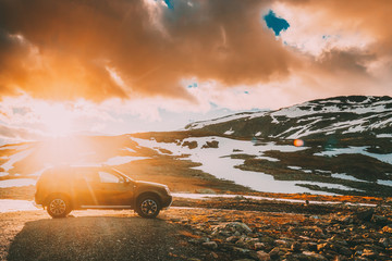 Wall Mural - Aurlandsfjellet, Norway. Car SUV Parked Near Aurlandsfjellet Scenic Route Road In Summer Norwegian Landscape. Popular Destination In Sunset Lights