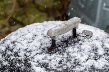 Kettle Drum Barbecue Covered In Snow While It Is Snowing In A UK Garden
