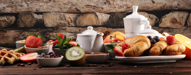 Breakfast served with coffee, orange juice, croissants, cereals and fruits. Balanced diet. Continental breakfast with granola and fruits