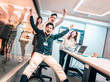 © Tom Wang - business people having fun riding on chairs in office