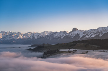 Wall Mural - swiss mountain range in switzerland while the valley is covered in fog during sunset, super warm lig