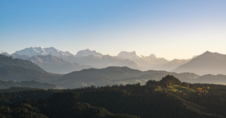 Canvas Print - swiss mountain range in switzerland while the valley is covered in fog during sunset, super warm lig