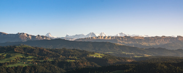 Wall Mural - swiss mountain range in switzerland while the valley is covered in fog during sunset, super warm lig
