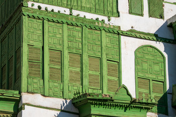 Wall Mural - Close-up view of the greenish Noorwali coral town house at the Souk al Alawi Street in the historic city center of Al Balad, Jeddah, Saudi Arabia