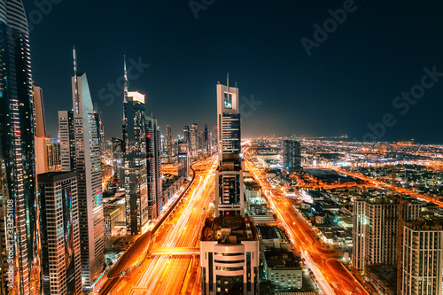 Photo Night view of the spectacular landscape of Dubai with high-rises and skyscrapers at the Sheikh Zayed highway