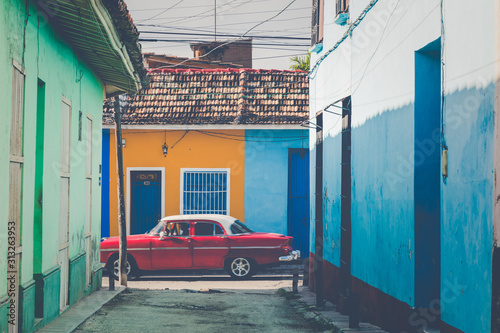 Photo Colorful houses and vintage cars in Trinidad, Cuba