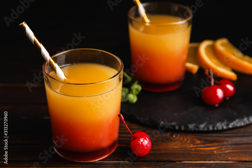 Cuadros en Lienzo Fresh alcoholic Tequila Sunrise cocktail on wooden table