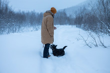 The Man Walks With His Dog In A Winter Forest