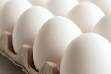 Detail of white chicken eggs in paper a tray.
