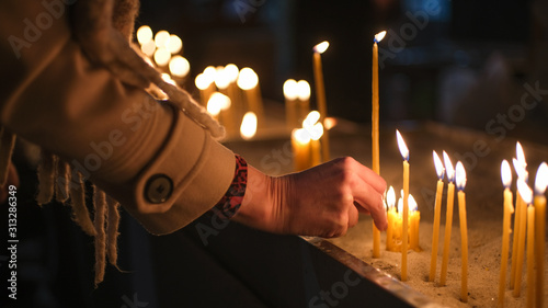 Fotomural Adult Caucasian light candle in Orthodox Church