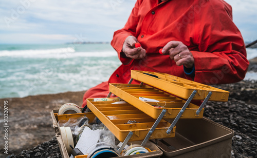 Fotomural Fisherman with fishing equipment box.