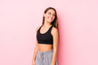 © Asier - Young caucasian fitness woman posing in a pink background looks aside smiling, cheerful and pleasant.