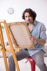 Young handsome man enjoying painting at home