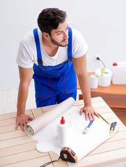 Worker working on wallpaper during refurbishment