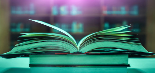 Poster - Stack of books in the library and blur bookshelf background	
