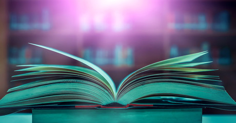 Poster - Stack of books in the library and blur bookshelf background	