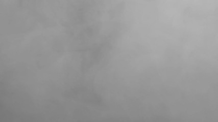 Wall Mural - White smoke on a black background. Start the cloud moving from the top left edge to the bottom right quickly. The concept of transitions for video editing using the alpha channel.