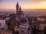 Fototapeta  - Bergamo, Italy. The old town. Amazing aerial view of the Basilica of Santa Maria Maggiore and the chapel Colleoni. Landscape of the city center and Its landmarks during a wonderful sunset