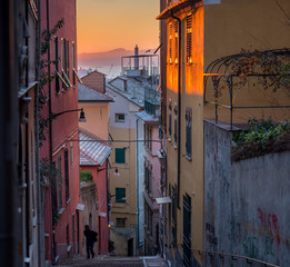 Beautiful scenic view of Genoa's (Genova) symbol of the city: Lanterna (lighthouse) view from the characteristic typical colorful narrow alleys (caruggi or vicoli) and colored houses of this old town