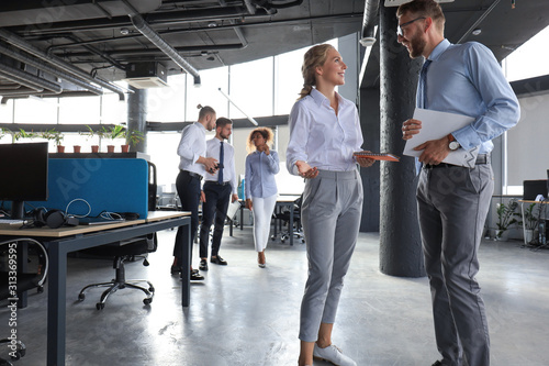Cuadros en Lienzo Group of modern business people are talking and smiling while standing in the of