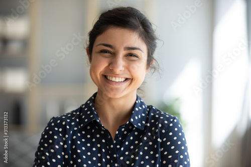 Fotomural Cheerful indian girl standing at home office looking at camera
