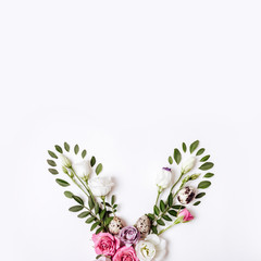 Bunny rabbit ears made of roses flowers, leaves and quail eggs. Happy easter concept, floral boho style