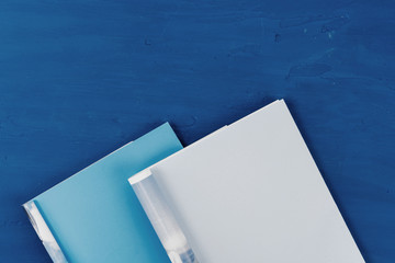 Canvas Print - Top view of open magazine page with copy space on classic blue background