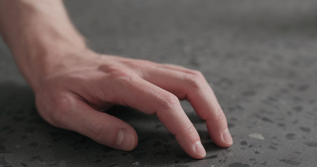 Poster - closeup man finger tapping on terrazzo countertop