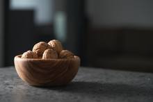 Inshell Walnuts In Olive Wood Bowl On Terrazzo Countertop