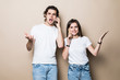 © F8  \ Suport Ukraine - Portrait of a happy young couple talking on mobile phones sitting together over beige background,