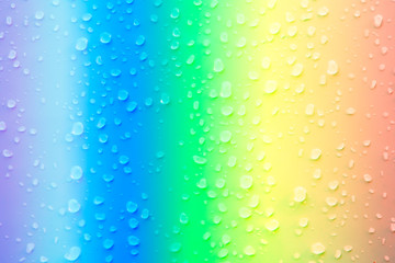  abstract water droplet above surface of rainbow color background