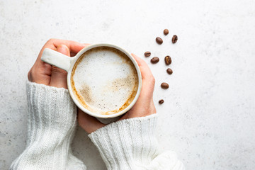 Wall Mural - Cup of coffee in womens hand on white background, top view