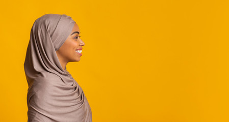 Wall Mural - Profile portrait of smiling black muslim girl in hijab