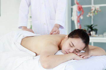 Wall Mural - hand of doctor performing acupuncture therapy . Asian female undergoing acupuncture treatment with a line of fine needles inserted into the her body skin in clinic hospital