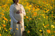 © torwaiphoto - Pregnant woman is relaxing in the flower garden.