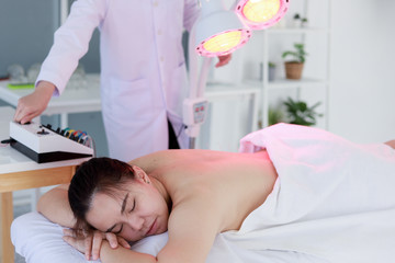 Wall Mural - hand of doctor performing acupuncture therapy . Asian female undergoing acupuncture treatment with a line of fine needles inserted into the her body skin in clinic hospital