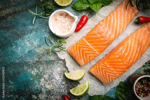 Cuadros en Lienzo Raw salmon fillet and ingredients for cooking, seasonings and herbs on a blue background