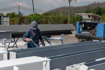 Wall Mural - The painter is working to painting color top coat on steel structure with spray gun, at industrial factory.